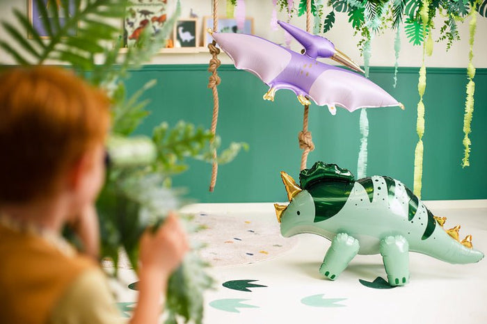 Standing triceratops foil balloon on strings, light green and dark green with gold horns