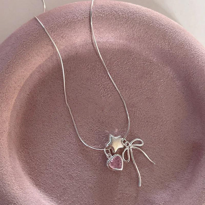 Silver-tone star and heart necklace with bow charms and pink heart stones