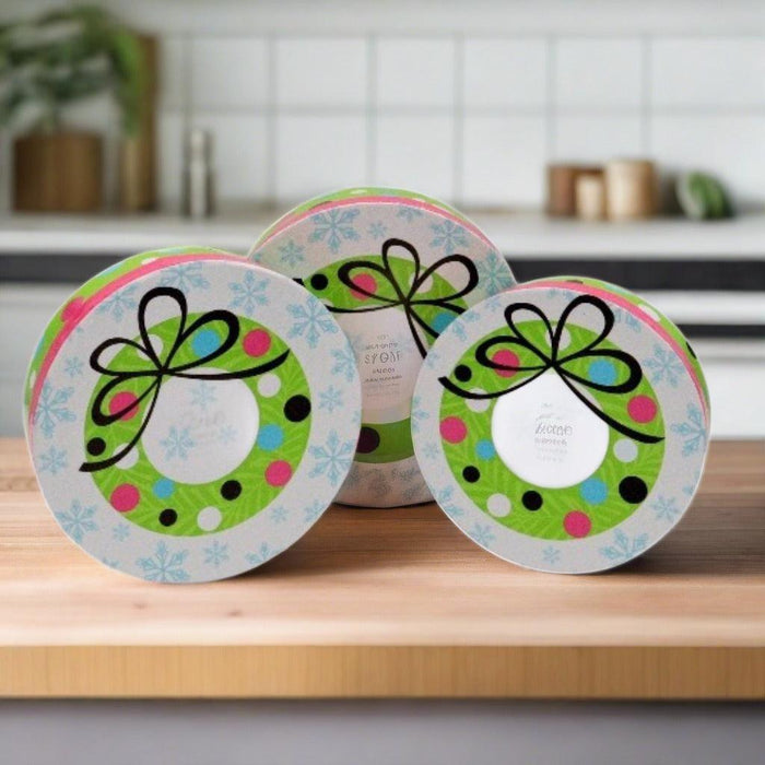 Three round tins for a holiday snack gift tower with polka-dot bows on lids