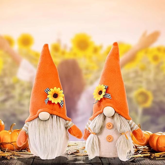 Two plush gnomes on fall-themed decor, orange hats with sunflower accents