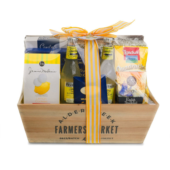 Summer gift basket in wooden crate with yellow ribbon and assorted gift boxes