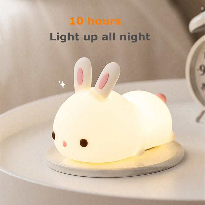 White bunny-shaped night light with glowing base and pink inner ears.