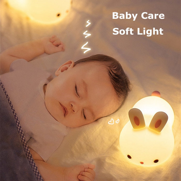 Bunny night light on a bed with warm glow through the bunny face and ears.
