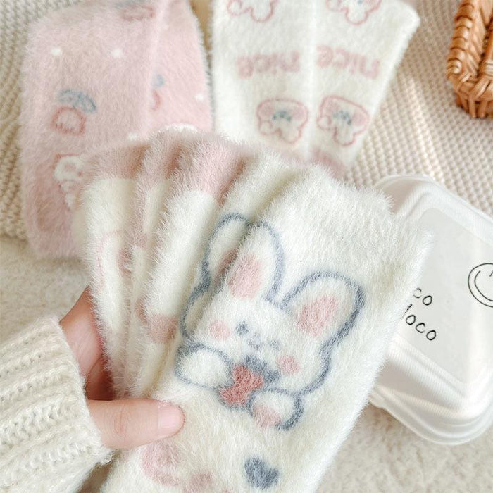 Close-up of folded bunny socks with blue bows and pink paw prints