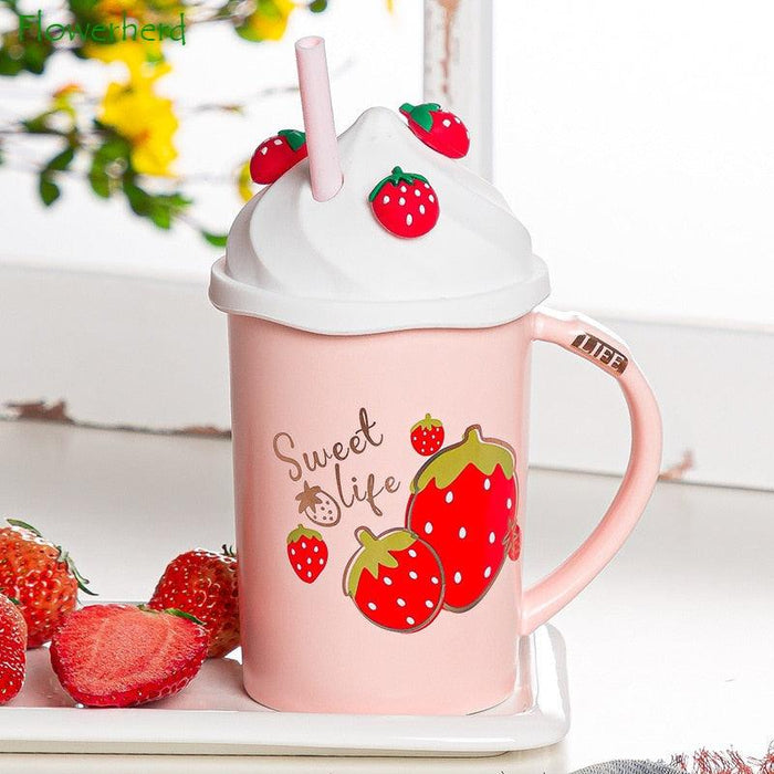 Pink mug with white lid and straw, strawberry fruit decals, handle visible