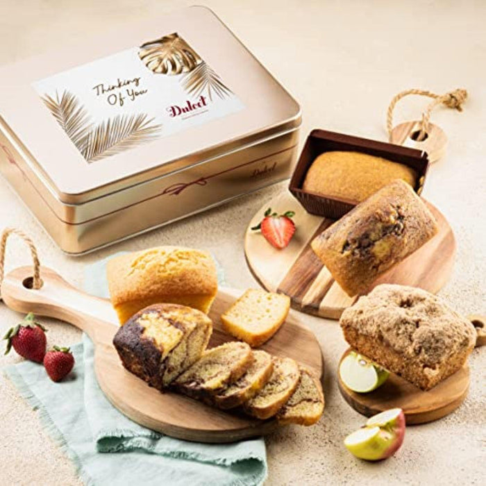 Tea loaf assortment in a gift tin with whole and sliced loaves on boards