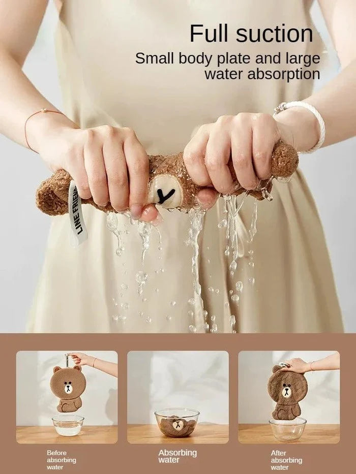 Brown teddy bear hand towel held up for drying, with bear face applique