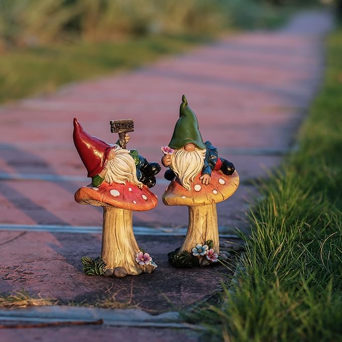 Resin garden gnome statues set of 2 on outdoor walkway, red and green mushroom tops