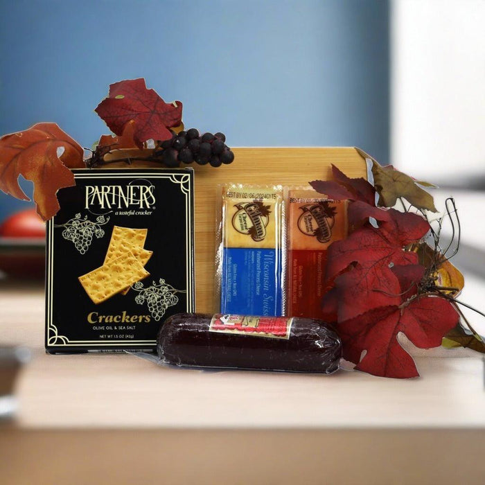 Charcuterie board gift set with crackers box, cheese sticks, sausage, and grapes