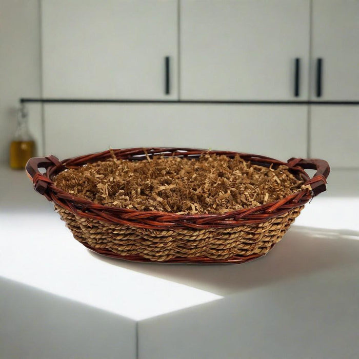 Woven gift basket with brown filler and dark ribbon handles