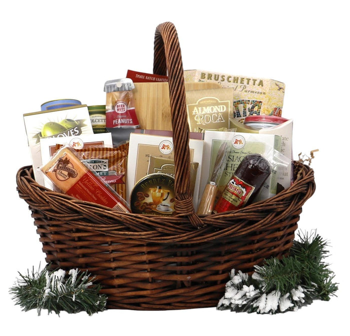 Wicker Christmas gift basket filled with assorted packaged snacks, nuts, and tins; pine decor