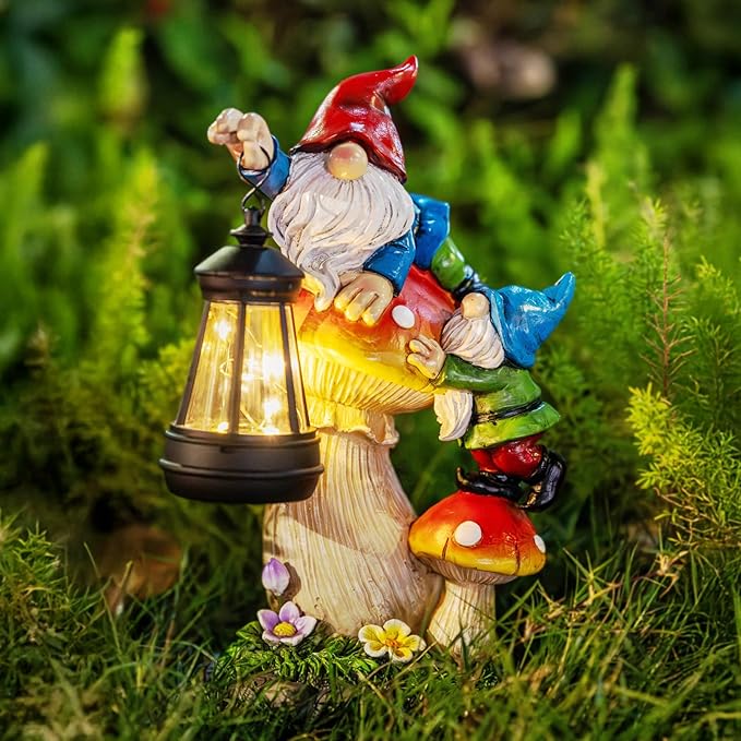 Close-up solar gnome statue holding a glowing lantern on grass, red hat and blue clothes