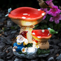Red mushroom bird water feeder with small gnome figurines and solar light