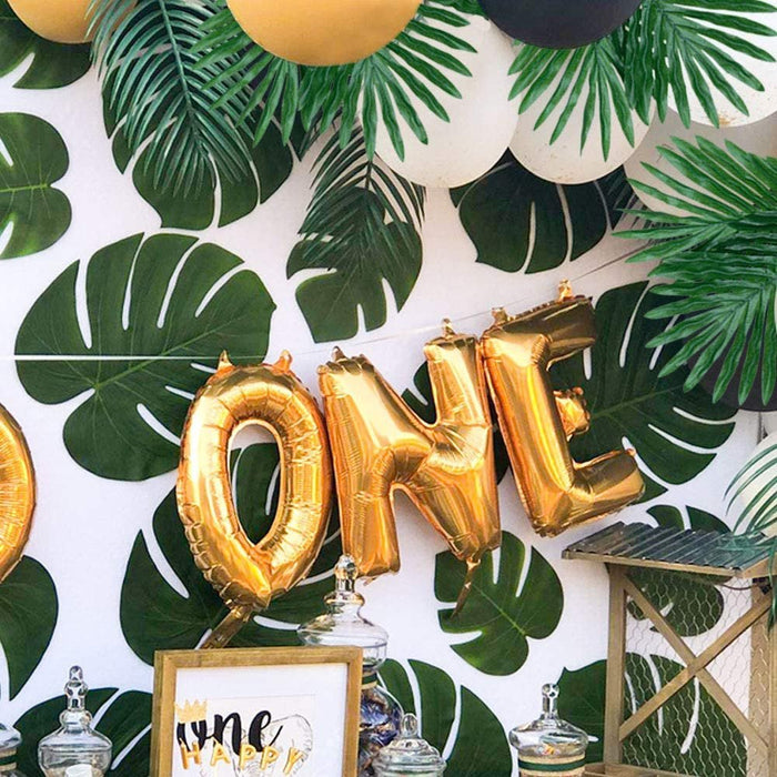 Green tropical leaf cutouts scattered across a party wall display