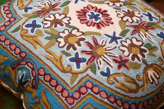 Turquoise floral pillow cover corner with patterned border and multicolor flower motifs