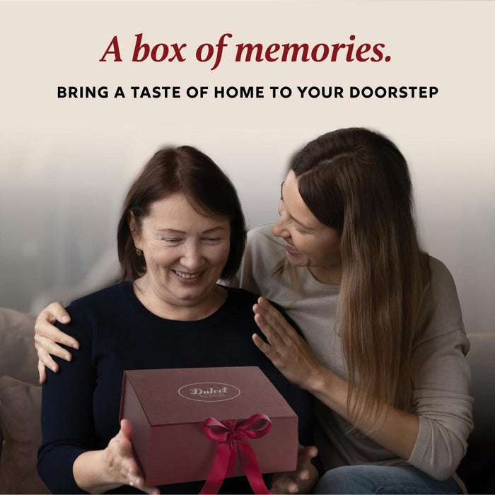 Two people holding a ribboned gift box while smiling