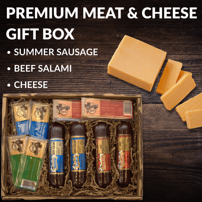 Meat and cheese gift box with cheese wedges, salami, and crackers on a wooden board