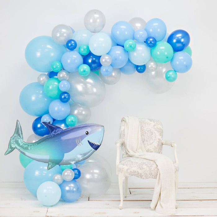 Balloon garland arch with blue, white, and aqua balloons and shark centerpiece