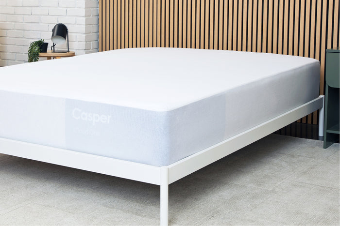 A waterproof mattress protector covering an entire mattress on a bed frame
