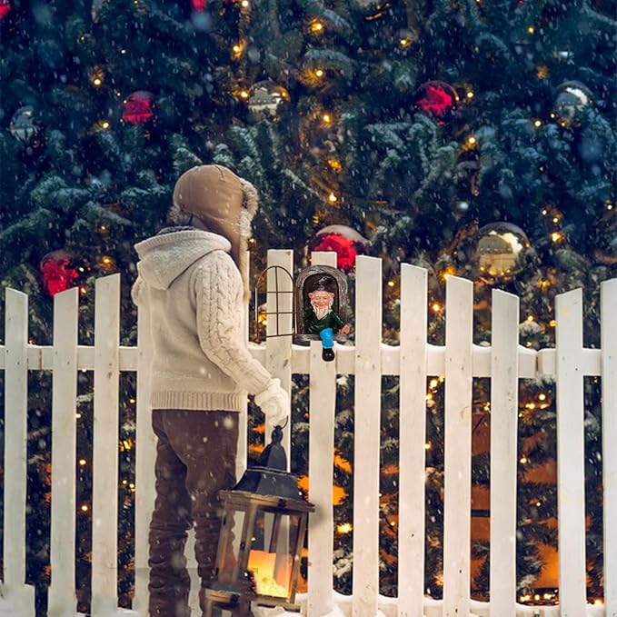 Garden gnome statue with white beard holding a small lantern beside a fence