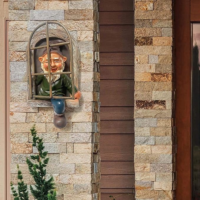 Garden gnome statue peeking from arched window set in stone wall, green coat and blue legs