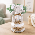 Two-tier baby diaper cake gift with plush elephant, diaper layers, leaf accents, ribbon ties