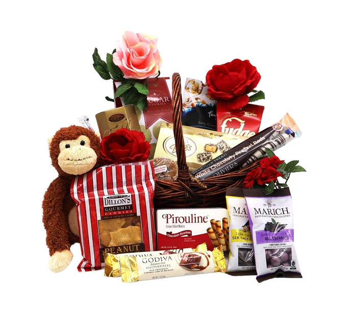 Gift basket with plush monkey, pink and red roses, and assorted chocolates and snacks