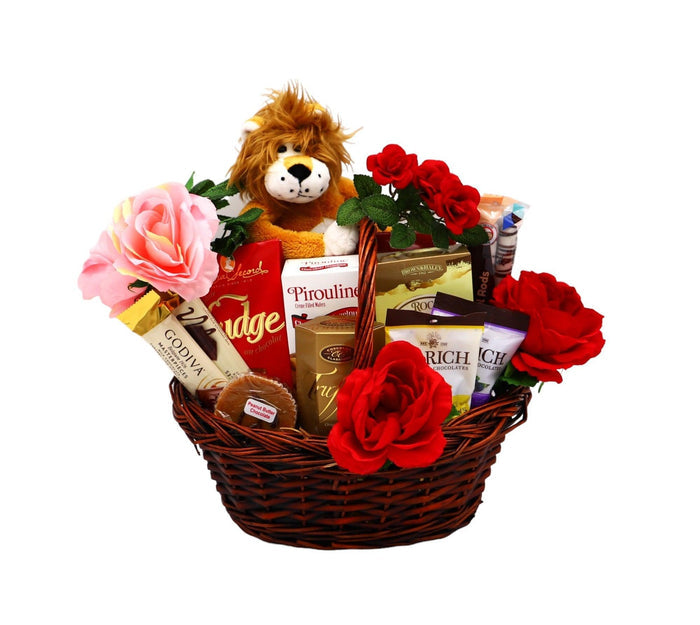 Gift basket with plush lion, red flowers, and assorted chocolate bars and treats