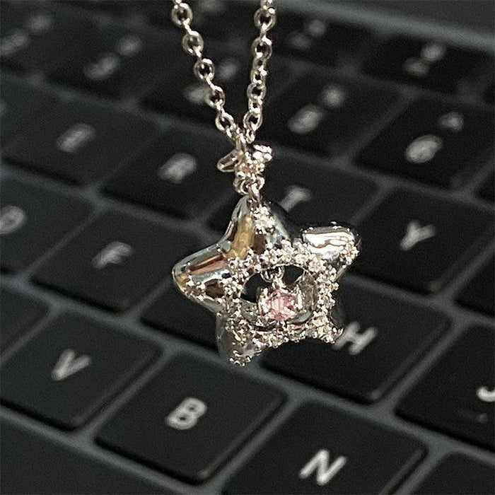 Star pendant necklace with silver chain and star charm, pink center surrounded by clear stones