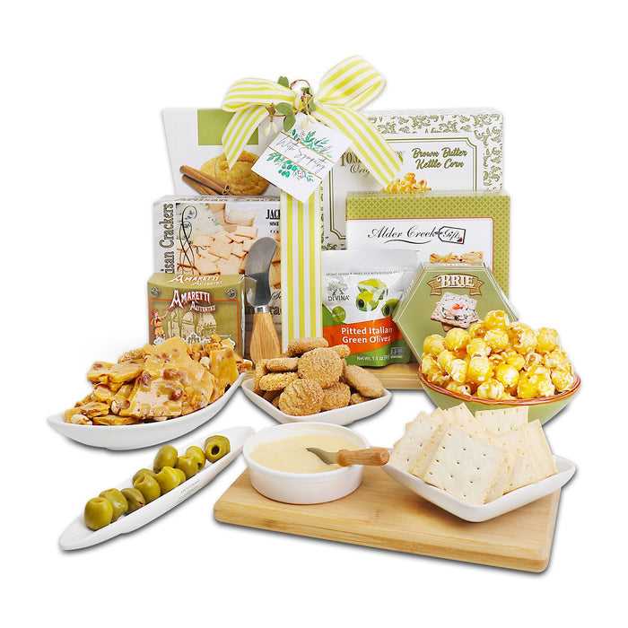 Gift basket with cutting board featuring olives, crackers, and cheeses with a green bow