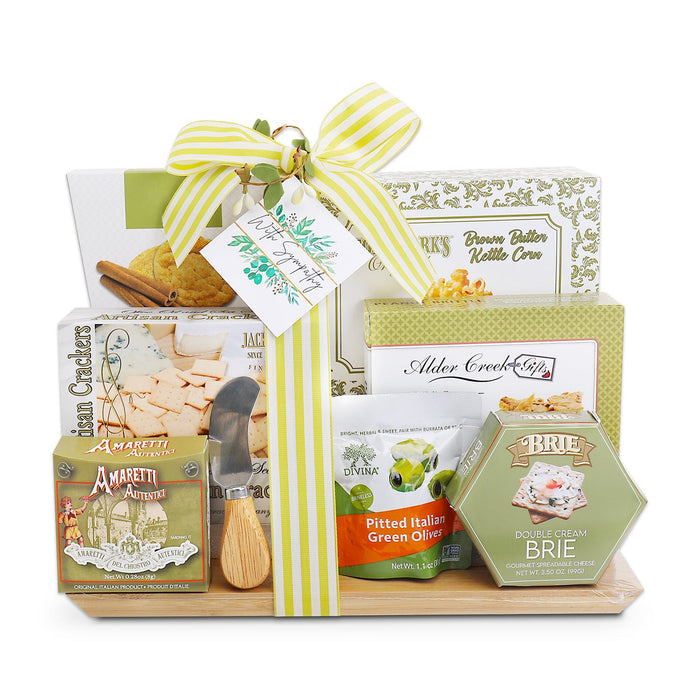 Gift basket with cutting board, wrapped cheese boxes, crackers, and olive snacks, green ribbon