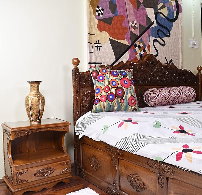 Floral embroidered accent pillow with multicolor ring pattern on a bed