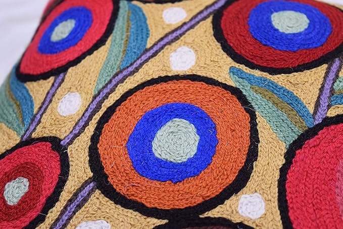 Wool pillow cover close-up with stitched circular motifs in blue, red, and orange