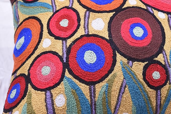 Embroidered pillow cover with red, blue, and orange circular flower motifs and dots