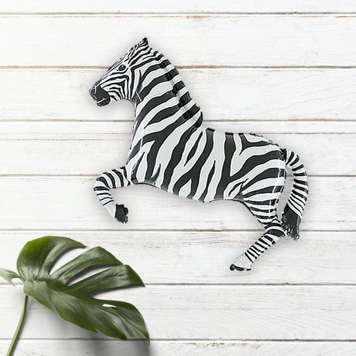 Zebra balloon in black-and-white zebra stripes, lying on its side with bent legs