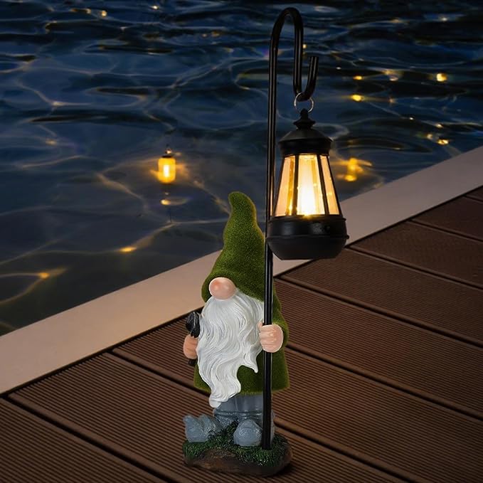 Solar gnome statue with lit lantern beside water, green hat and white beard, outdoor resin decor