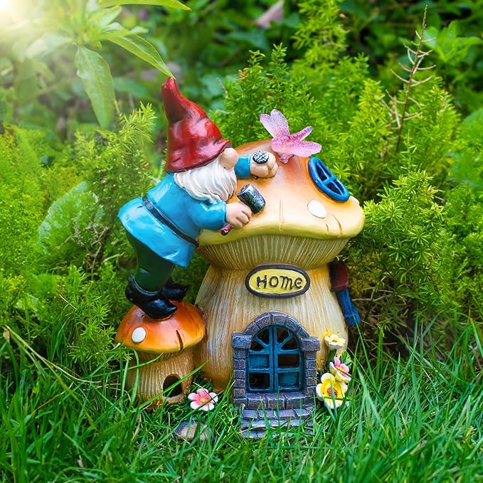Solar gnome lantern house figurine with red hat, standing among green grass